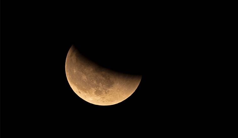 Earth's shadow obscuring part of the moon during the lunar eclipse 2022