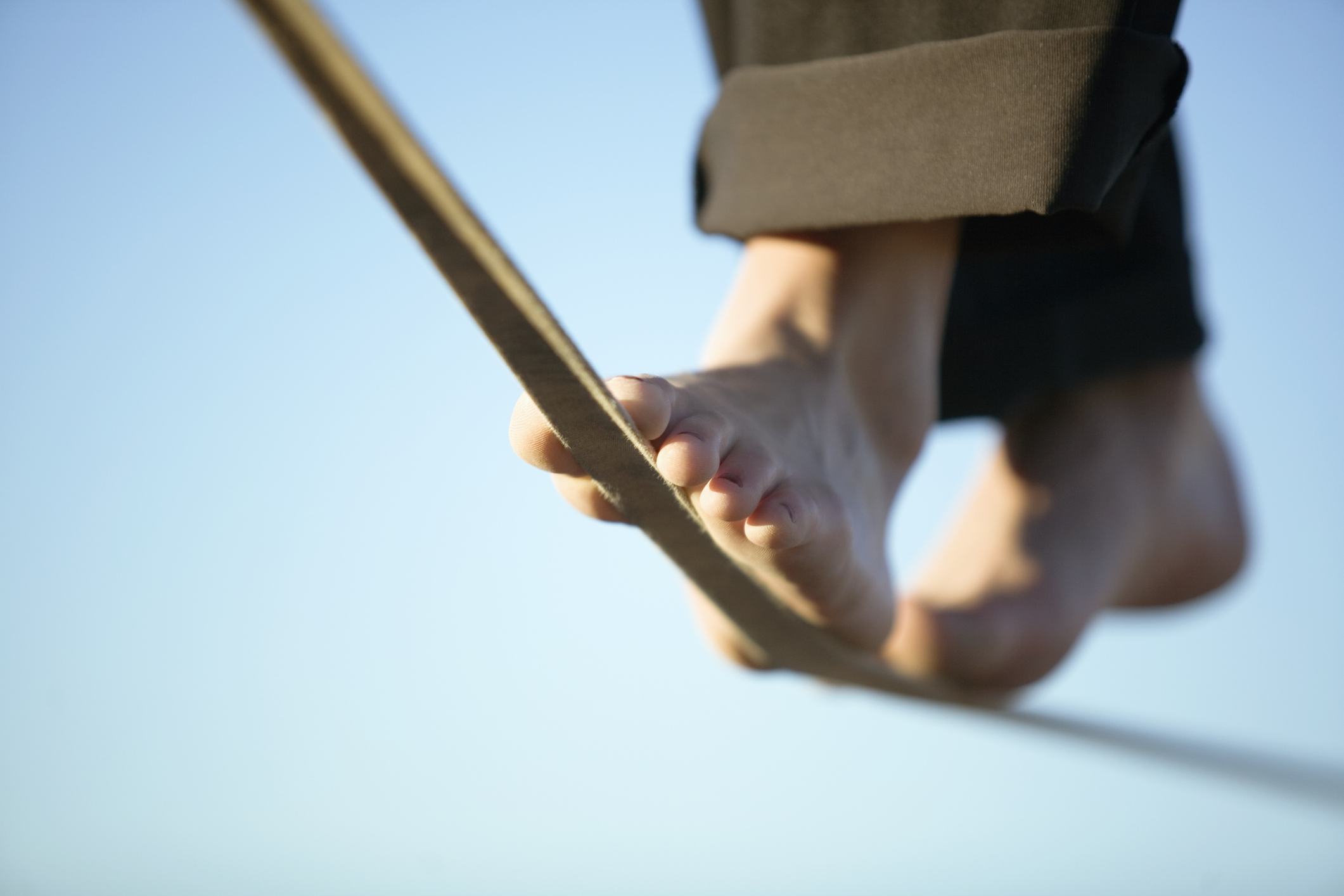 Woman slacklining in bare feet; tightrope