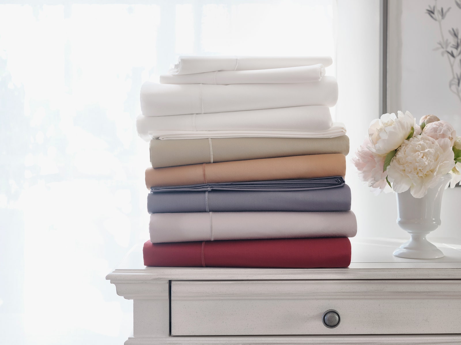 JCPenney wrinkle guard sheets stacked on a bedroom table