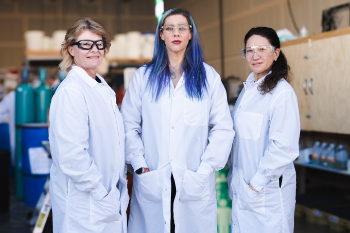 Three women standing in a lab.