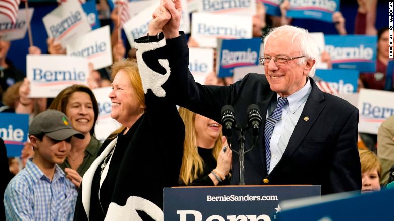 Sanders holds the hand of his spouse Jane O&#39;Meara Sanders as he takes the stage during a primary night event on February 11, 2020 in Manchester, New Hampshire. 