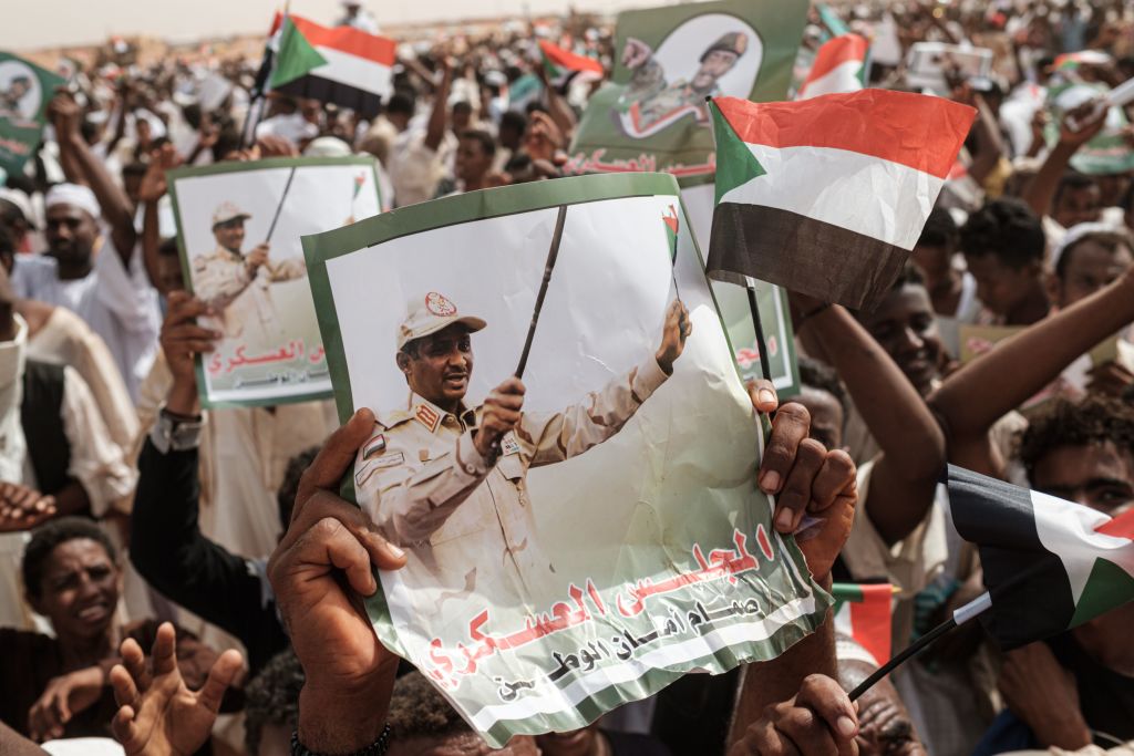 Supporters hold portraits of Hemeti before a rally in the village of Abraq, about 60km north-west of Khartoum, Sudan