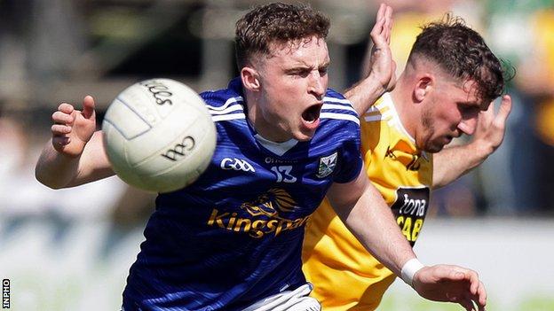 Cavan's Cormac O'Reilly wins possession in a duel with Antrim's Ryan Murray