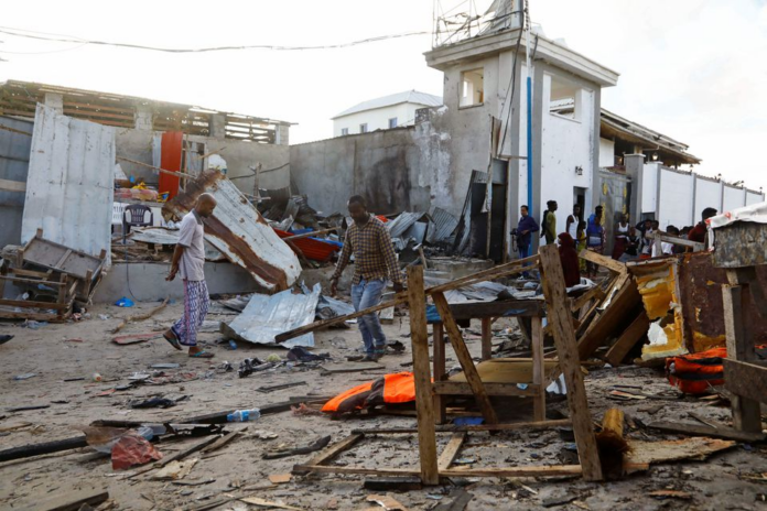 Bystanders walk through the scene of bombing at a seaside restaurant at Liido beach in Mogadishu, Somalia April 23, 2022. REUTERS/Feisal Omar