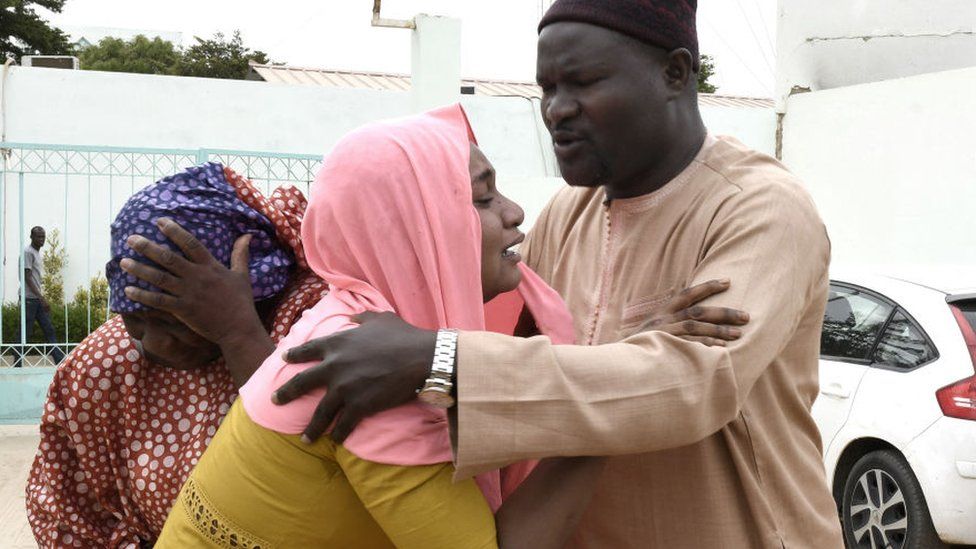 Family members console each other outside the Mame Abdoul Aziz Sy Dabakh Hospital, where eleven babies died following an electrical fault, in Tivaouane, on May 26, 2022