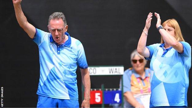 Scotland lawn bowl director George Miller celebrates alongside Melanie Inness during the mixed pairs B2/B3 gold-medal final against Wales