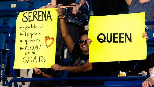 Fans hold signs declaring Serena the GOAT