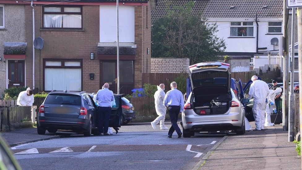 Forensic officers and police cars near the house in which Liam Christie was shot