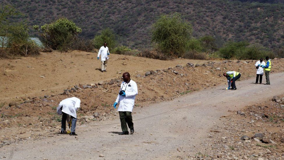 Forensic team searching a road