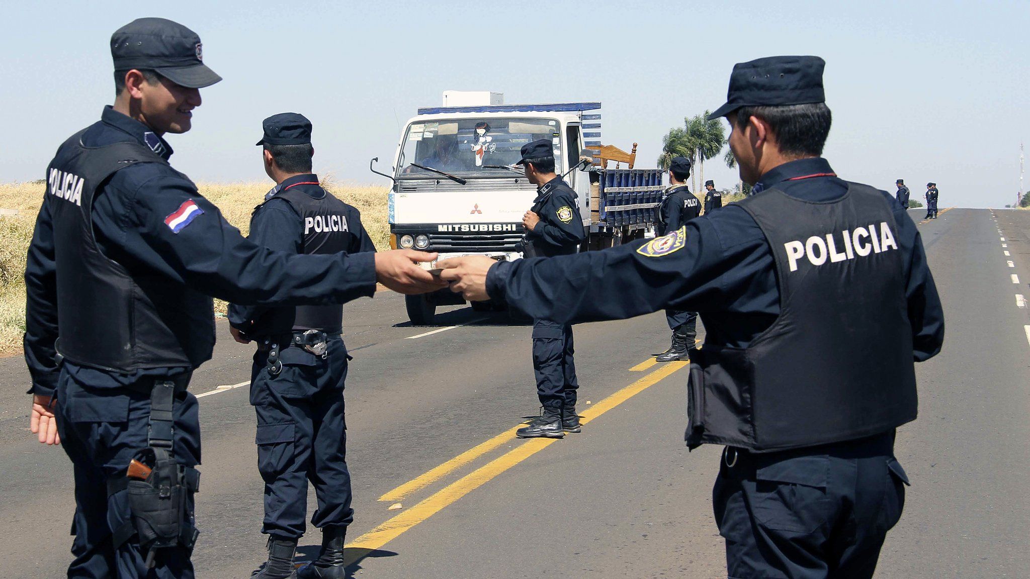 Paraguayan police officers patrol the area where five security guards of a ranch were murdered by EPP guerrillas, in Tacuati, 400 km north of Asuncion, on August 19, 2013