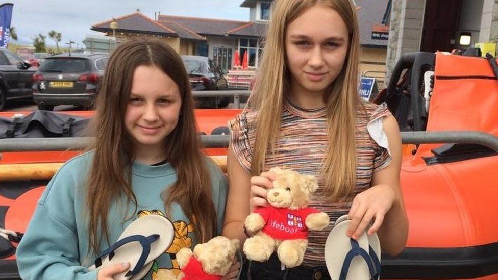 Elsie and Mabel in front of a lifeboat