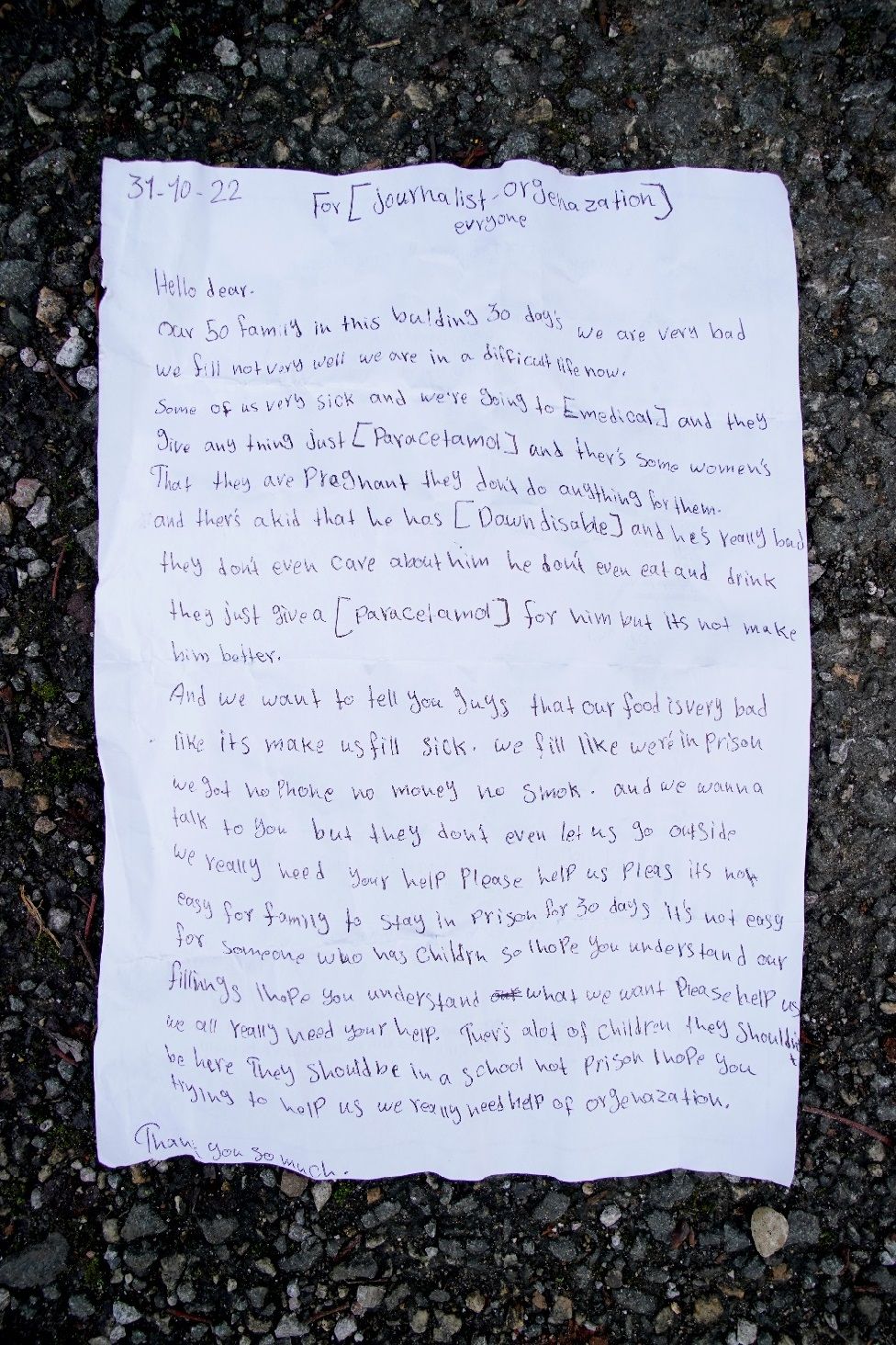 A letter thrown by a young girl over the fence at the Manston immigration short-term holding facility located at the former Defence Fire Training and Development Centre in Thanet, Kent