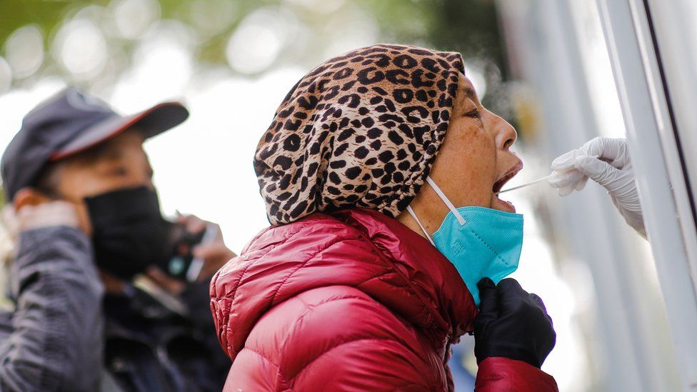 A woman undergoes a PCR test as per routine testing in Beijing