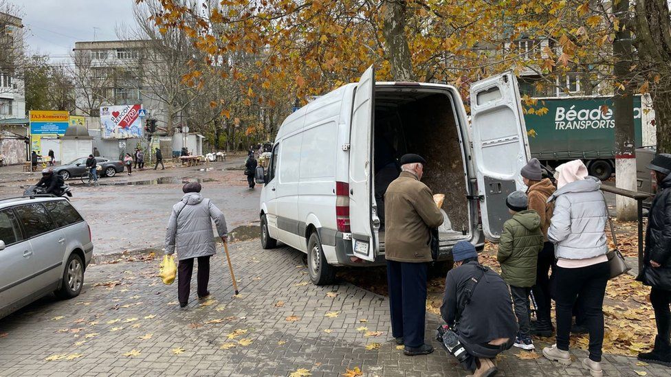 In a picture of "cause and effect", bread is handed out under pro-Moscow billboards which read "Together with Russia".