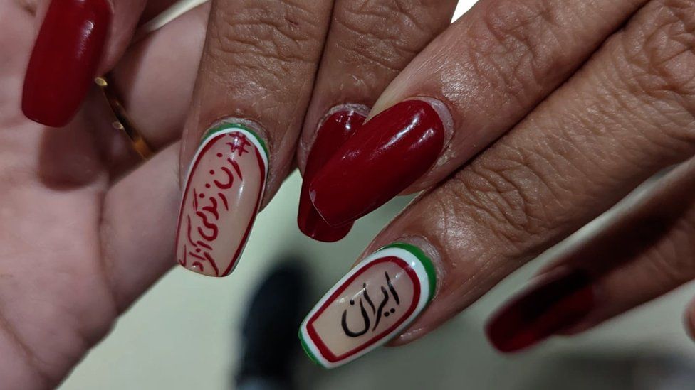 The nails of Iranian female football fans have the protest slogan 'women, life, freedom' written on them