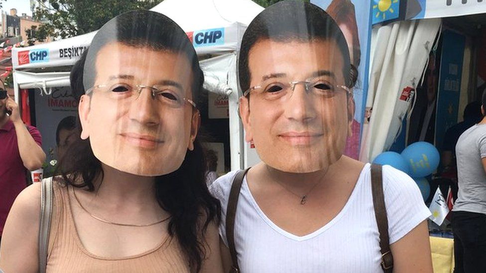 Two women wearing Imamoglu masks