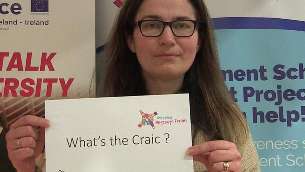 Student holding 'What's the craic?' sign