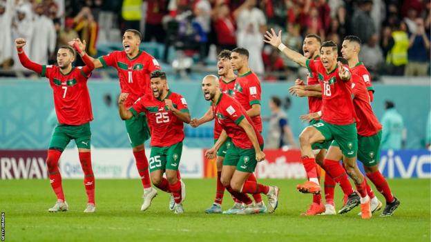 Morocco players rush to congratulate the taker of the winning penalty against Spain