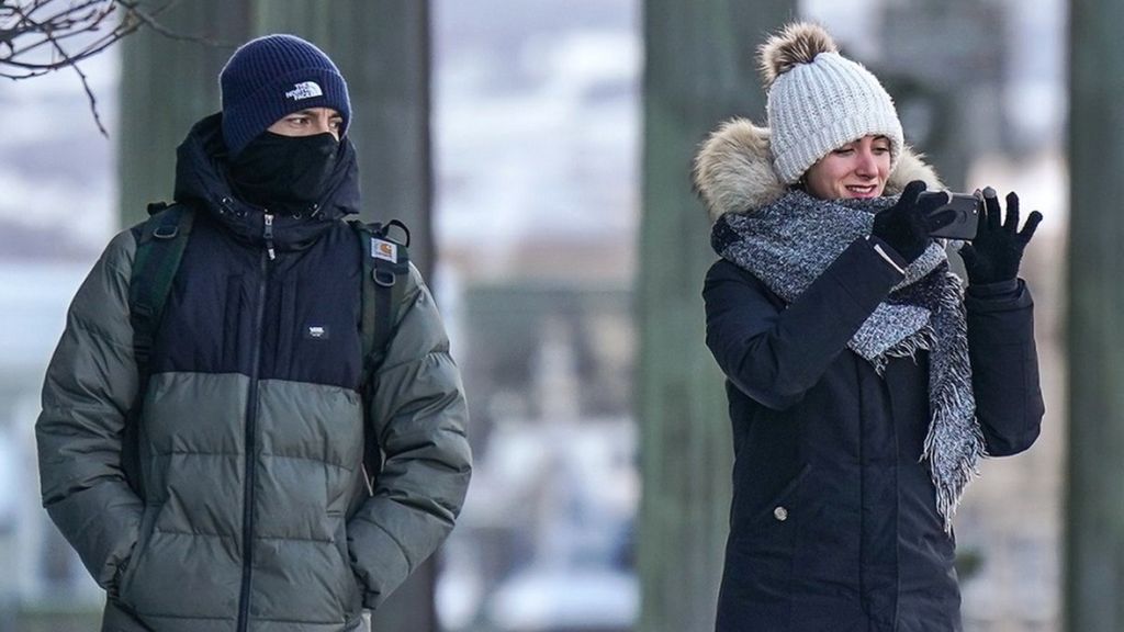 A man and a woman wrap up warm as they stroll through Edinburgh