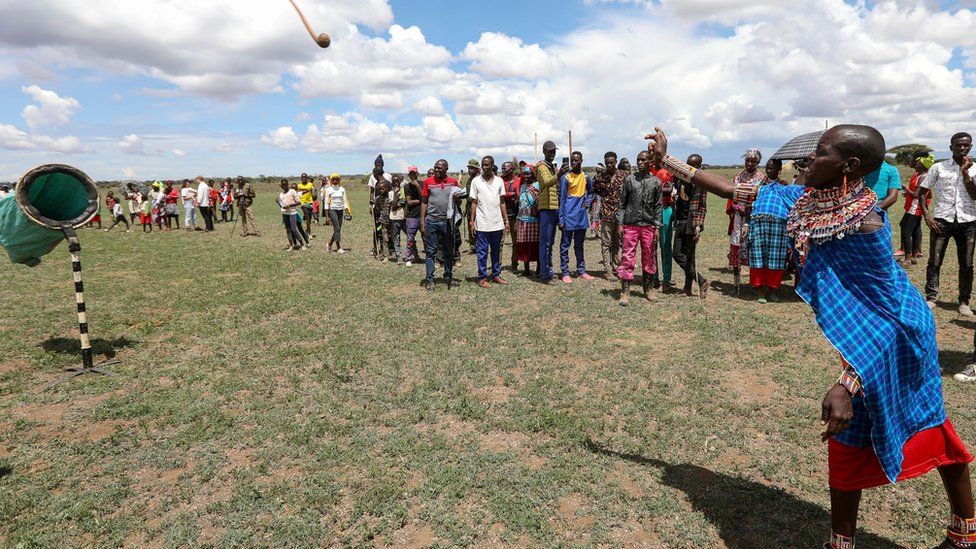 A Maasai Woam has a go in the rungu (or Maasai traditional war-club) throwing competition