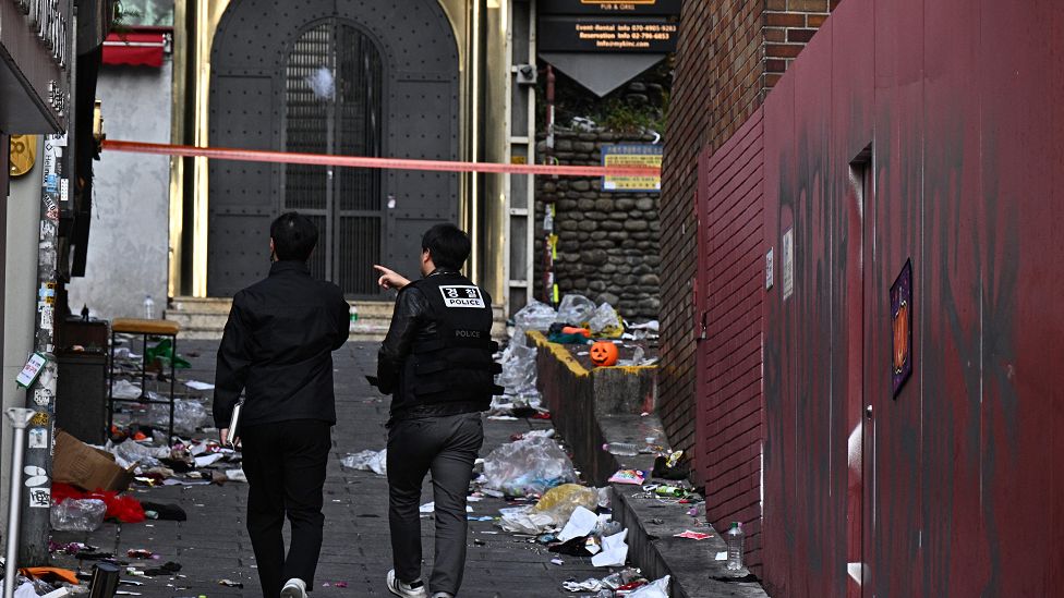 Two police officers walk down an alley in Itaewon two days after the crush that killed 156 people