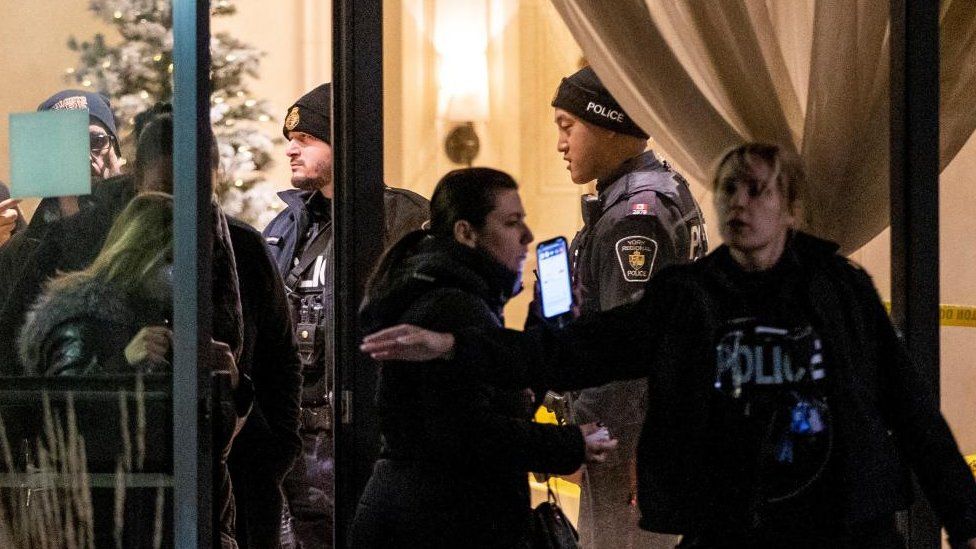 Police officers evacuate residents from a building where a mass shooting occurred in Canada