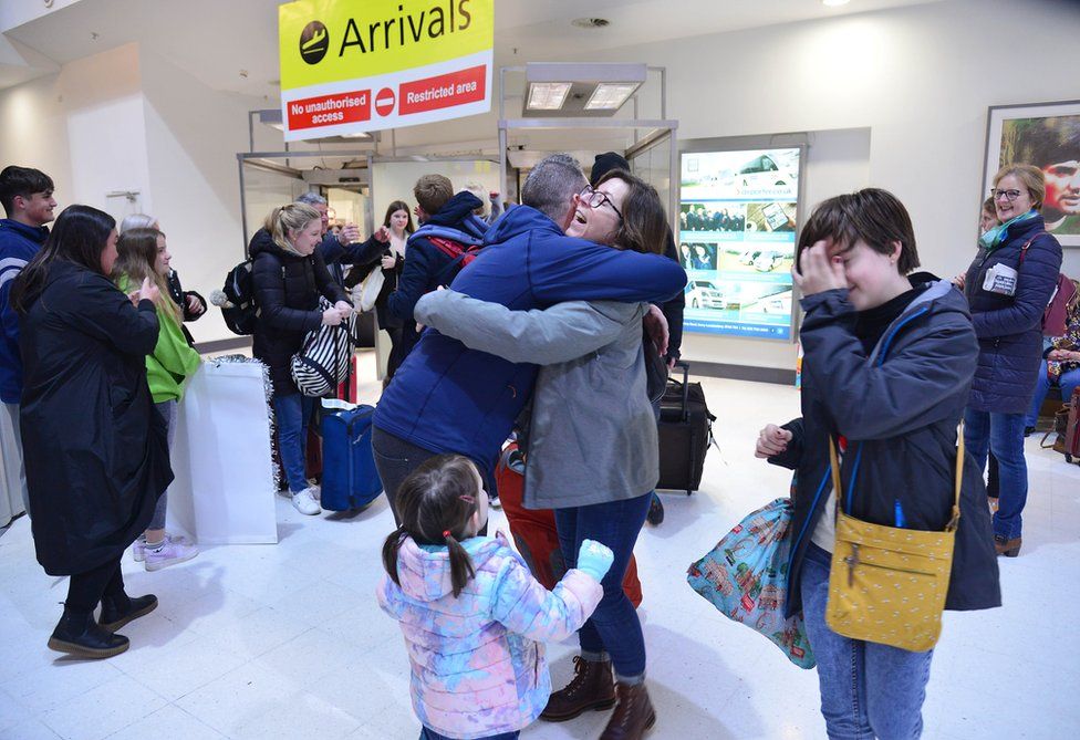 Relatives hug as they are reunited at Belfast City Airport