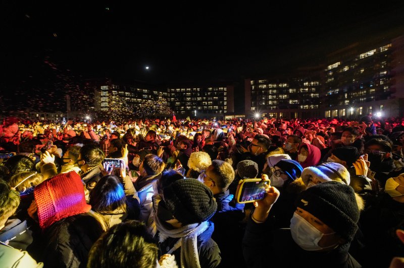 People wearing face masks watch a fire show on New Year’s Eve at Aranya Resort in Qinhuangdao, China, on December 31. China said it expects domestic travel to double for its Lunar New Year. Photo by Wu Hao/EPA-EFE