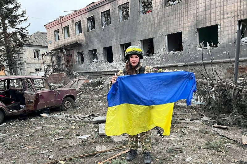 Ukrainian soldier in a police building damaged after a Russian missile strike in Lyman, Ukraine on December 31 displays a Ukrainian flag. Russia continued its attack through the Orthodox Christmas this weekend. Photo by Ukrainian Police /UPI