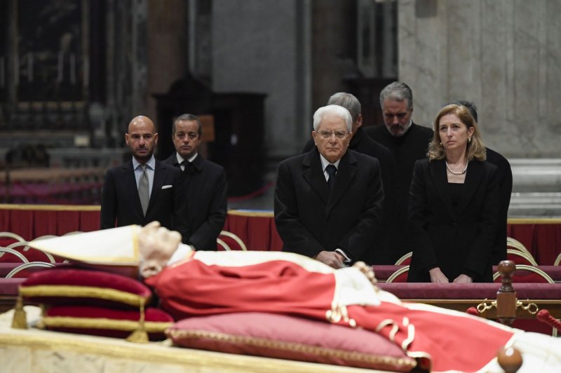 Italian President Sergio Mattarella (C) pays homage to Pope Emeritus Benedict XVI as he lies in state inside St. Peter's Basilica in Vatican City on Monday. Photo by Stefano Spaziani/UPI | <a href="/News_Photos/lp/2a2df38cef966c40dd6cd1b5419ffb99/" target="_blank">License Photo</a>