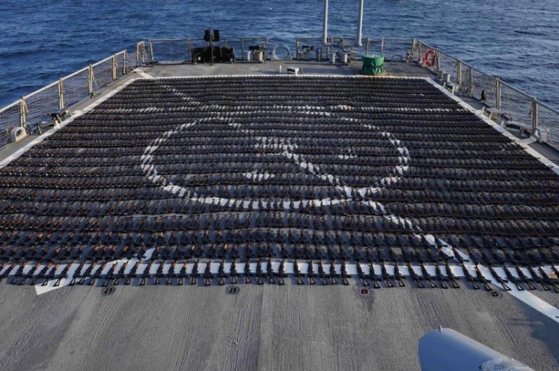 Thousands of AK-47 assault rifles are displayed on the flight deck of guided-missile destroyer USS The Sullivans on Saturday during an inventory process. U.S. naval forces seized the 2,116 assault rifles from a fishing vessel along a maritime route in the Gulf of Oman between Iran and Yemen. Photo courtesy of U.S. Navy