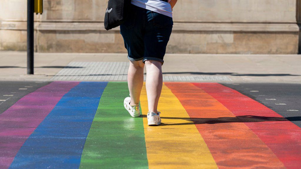 Woman walking over the rainbow crossing in Battersea