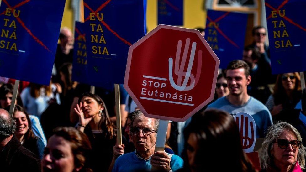 People attend a protest against the decriminalization of euthanasia in front of the parliament on February 20, 2020 in Lisbon