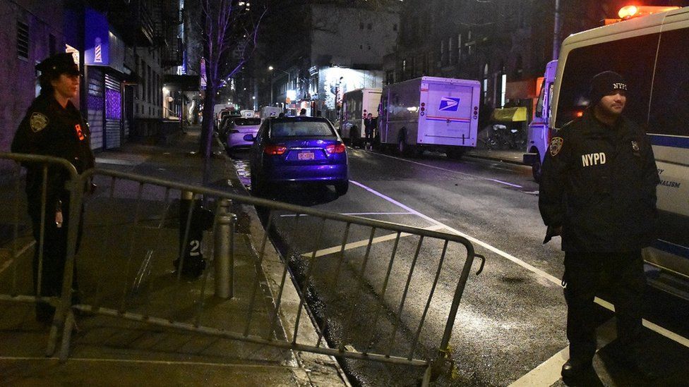 Police officers stand guard on a road after a 19-year-old assailant attacked three NYPD officers with a machete near Times Square during the new year celebrations in New York, United States on December 31, 2022