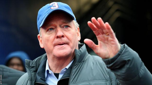 NFL commissioner Roger Goodell attending the Bills-Patriots game wearing a blue cap with the number three on it