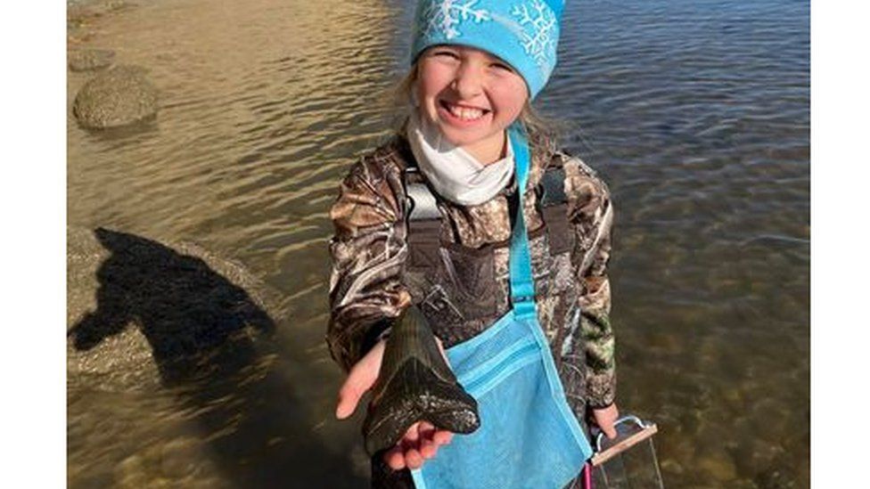 Molly poses with her megalodon tooth