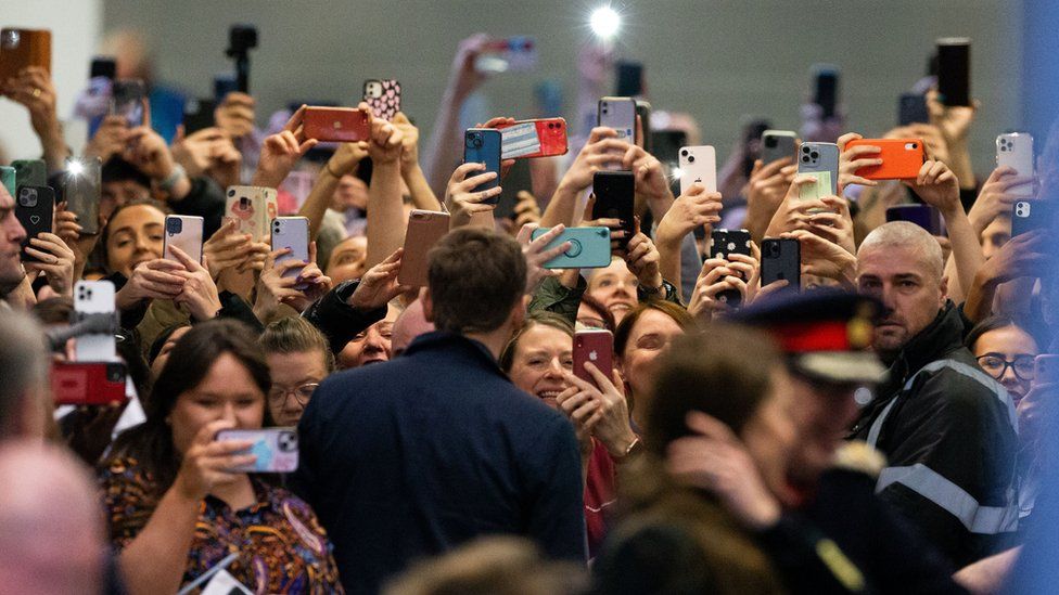 Crowd take pictures of couple