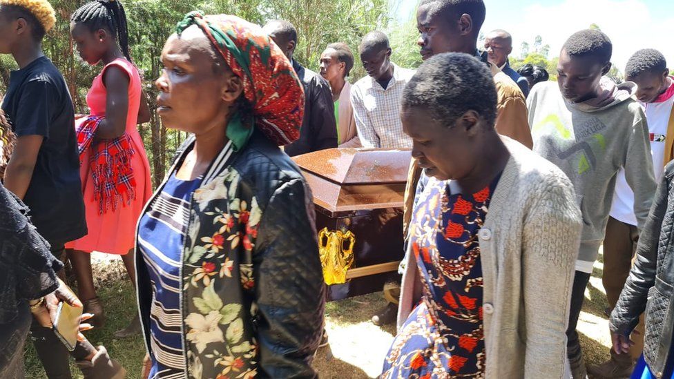 Family walking with a coffin