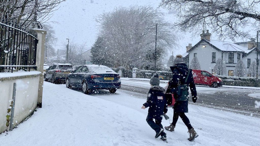 Two people walking in snowy Eglinton