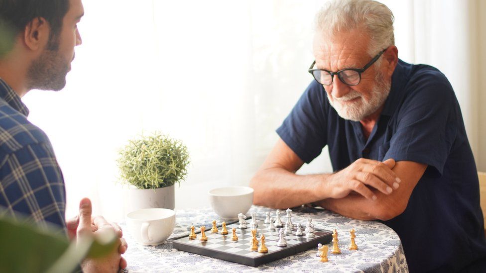 man playing chess with his son