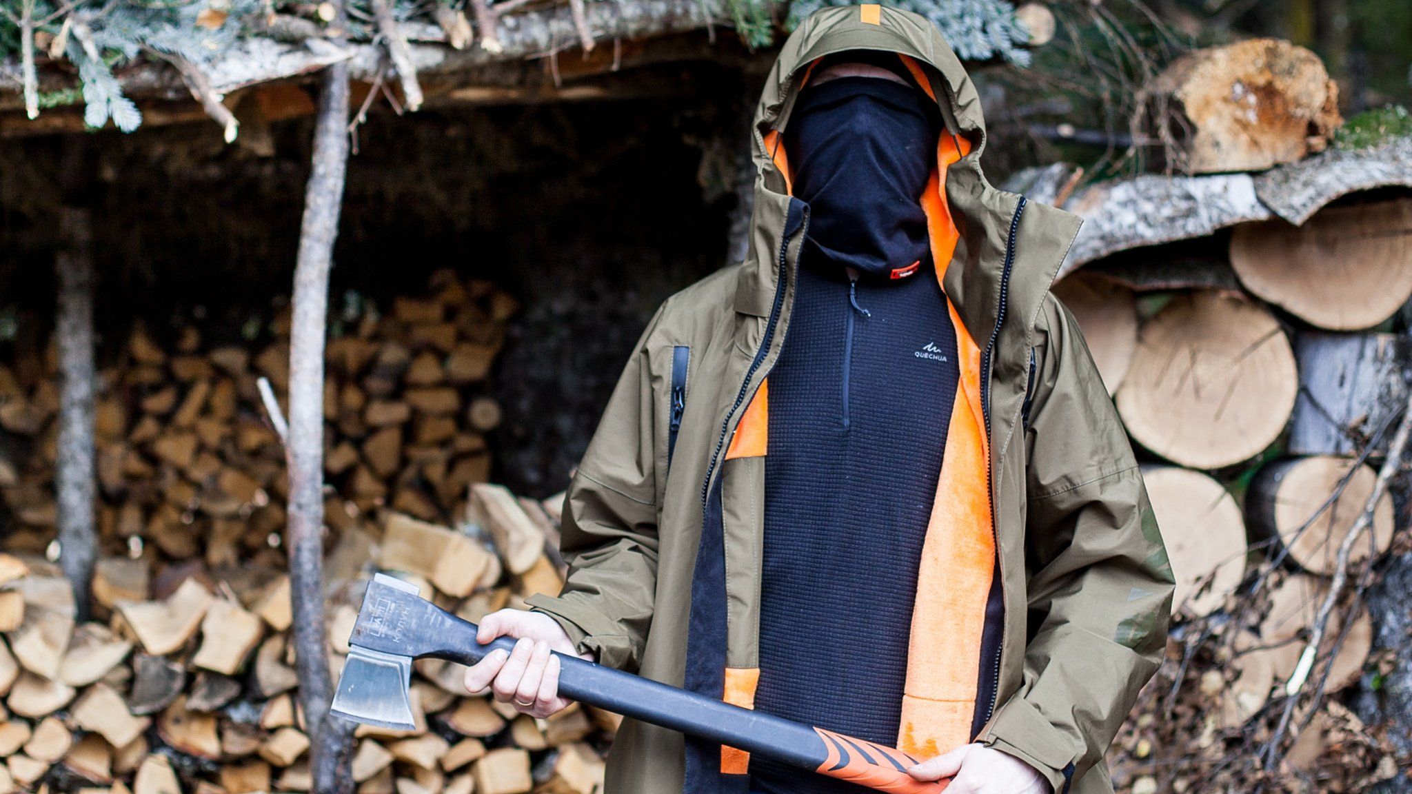 Adam Kalinin holds and axe with his face covered by a scarf