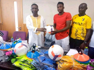 Black Stars player, Baba Abdul Rhaman (middle) presenting the items