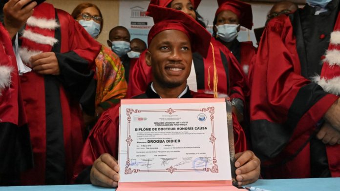 Didier Drogba poses for a photograph after receiving an Honorary degree from the University of Sciences and Technology of Africa network (RUSTA) in Abidjan