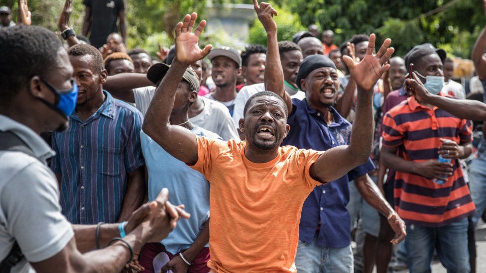 The crowd reacts near the Police station where armed men are being detained