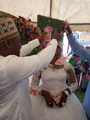 Alhassan Suhuyini spraying money on the bride