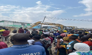 Residents gather around to help demolish buildings