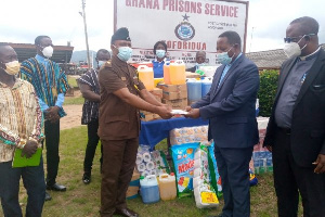 Rev Amfo Akonor makes a cash presentation to head of the prisons