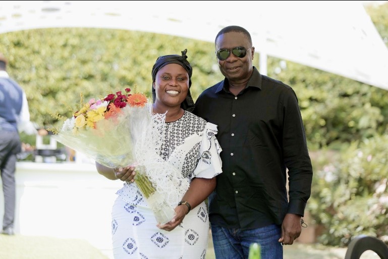 May be an image of 2 people, people standing, flower and outdoors