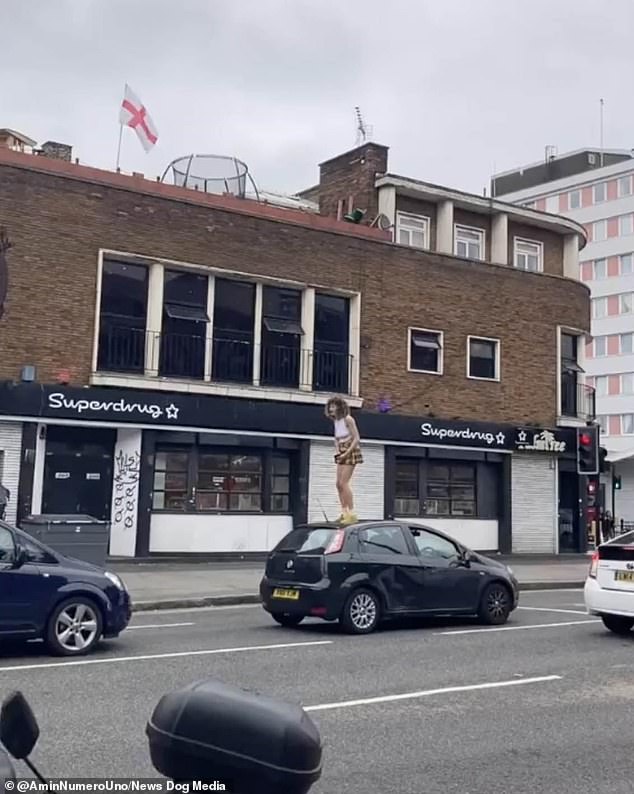 The young woman was seen doing a jig on the roof of this Fiat in London traffic on Bank Holiday Monday