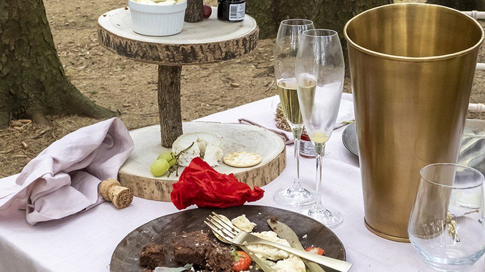 Remains of half eaten food and champagne cork and glasses